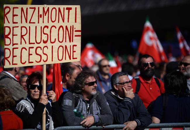 A woman holds a banner reading “Renzi-Monti-Berlusconi = Recession” during a demonstration organized by Italian General Confederation of Labor union on Saturday in central Rome as part of a nationwide protest called by the union to protest Prime Minister Matteo Renzi’s plans to overhaul the labor market.    AFP-Yonhap
