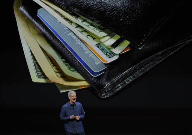Apple’s CEO Tim Cook unveils Apple Pay during a product announcement at Flint Center in Cupertino, California, Sept. 9.   Bloomberg