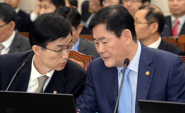 Finance Minister Choi Kyung-hwan (right) discusses key economic issues with his deputy during an audit on the ministry’s fiscal policies at the National Assembly in Seoul on Monday.   Ahn Hoon/The Korea Herald