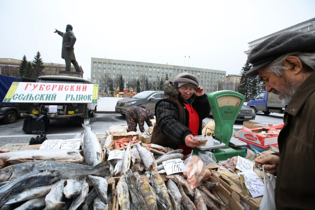 A statue of Vladimir Lenin stands in a central square near a monthly street market where a vendor exchanges Russian ruble banknotes with a customer at her fresh fish stall in Sovetov, Keremovo region, Russia, on Friday, Oct. 24, 2014. While Russia dodged being cut to junk by Standard & Poor's last week, the bond market is signaling mounting concern a downgrade is coming as economic growth sputters amid tumbling oil prices. Photographer: Andrey Rudakov/Bloomberg
A vendor exchanges Russian banknotes at her fish stall in Sovetov, Russia, Friday.   Bloomberg
A vendor exchanges Russian banknotes at her fish stall in Sovetov, Russia, Friday.   Bloomberg