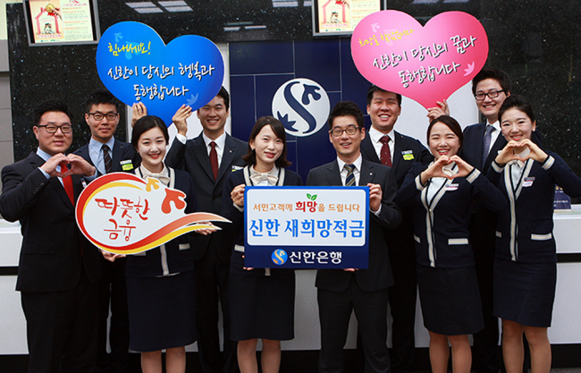 Shinhan Bank employees celebrate after the “New Hope Savings” service for low-income earners attracted more than 21,000 customers this year.   Shinhan Bank