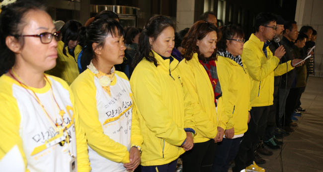 Families of victims of the Sewol ferry disaster hold a news conference in front of the National Assembly on Tuesday.  (Yonhap)