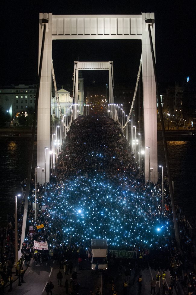 Thousands of demonstrators flash their mobile phones as they march through Elizabeth Bridge across River Danube in Budapest, Hungary, Tuesday.    AP-Yonhap