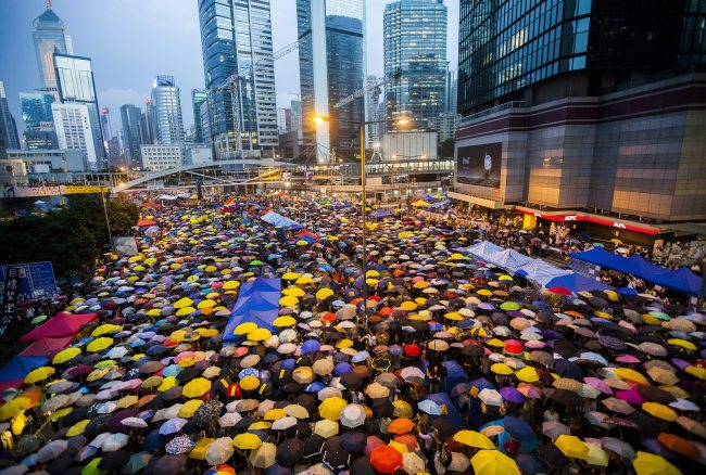 Pro-democracy protesters open their umbrellas for 87 seconds, marking the 87 rounds of tear gas that were fired by the Hong Kong police at unarmed student protesters in exactly the same location one month ago, at the Admiralty district in Hong Kong on Tuesday.   EPA-Yonhap