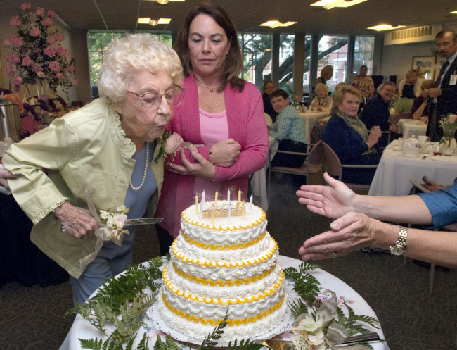 Ann Downing Kay, born in 1907, blows out candles on a cake with help from her granddaughter Jenna Grifo on Oct. 16 at the Pickersgill Retirement Community in Towson, Maryland. (MCT)
