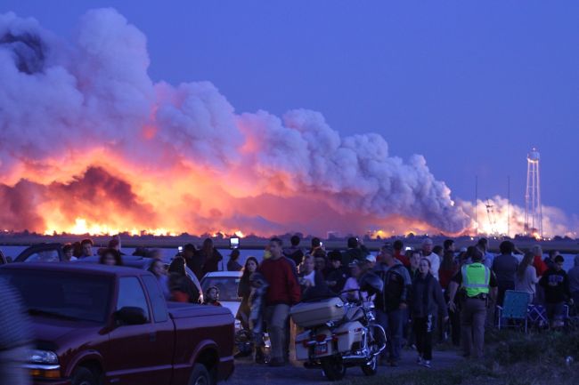 People who came to watch the launch walk away after an unmanned rocket owned by Orbital Sciences Corporation exploded Tuesday just seconds after liftoff from Wallops Island, Virginia, on what was to be a resupply mission to the International Space Station.   AFP-Yonhap