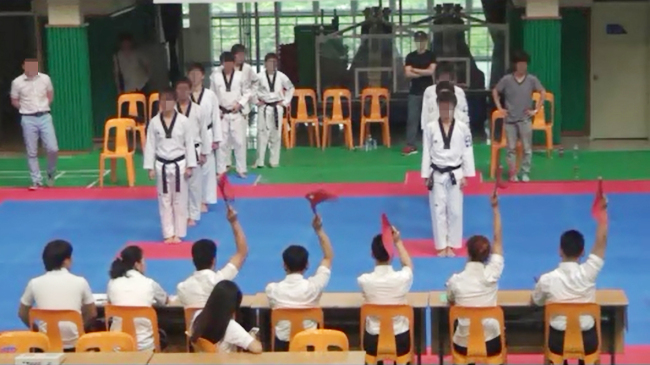 지난 2013년 7월 8일 경기도 의정부시의 한 대학에서 열린  ‘전국 추계 한마음태권도 선수권대회’ 고교 품새 단체전에서 승부조작에 항의하는 C팀 감독과 심판들이 일제히 붉은 깃발을 들어올리는 장면.