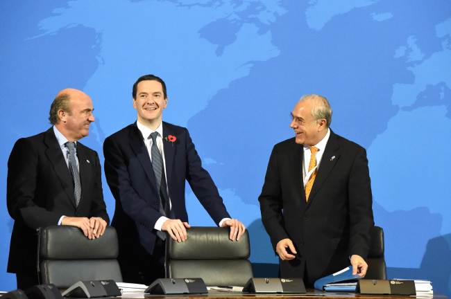 OECD Secretary-General Angel Gurria (right) speaks with British Finance Minister George Osborne (second from left) and Spanish Finance Minister Luis de Guindos Jurado during a press conference after the signing of the Multilateral Competent Authority Agreement by more than 80 countries in Berlin on Wednesday.    AFP-Yonhap