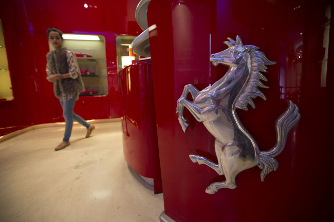 A woman walks in a Ferrari store in Rome.   Bloomberg