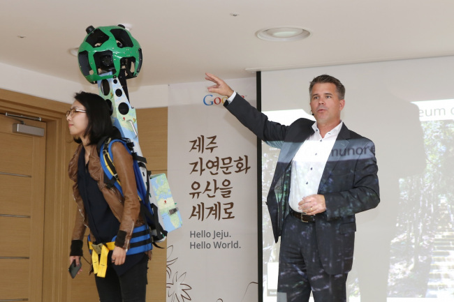 Google Street View program manager Ulf Spitzer (right) introduces the wearable camera backpack Trekker that was used to digitally capture Jejudo Island’s archeological landscapes. (Google)