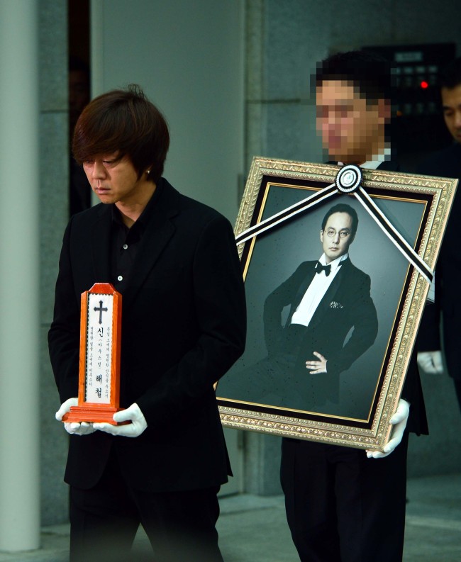 Singer Yoon Do-hyun holds the name plate of Shin Hae-chul as the singer’s coffin is carried into a hearse during a funeral ceremony at Seoul’s Asan Medical Center Funeral Home on Friday morning.
Yoon Byung-chan/The Korea Herald