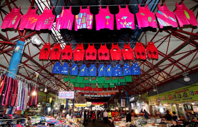 Aprons designed by Dream Gream students and Seoul Art Space Shindang artists hanging from the ceiling of Seoul Jungang Market.   Han Sung Motor