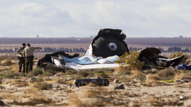Law enforcement officers take a closer look at the wreckage near the site where a Virgin Galactic space tourism rocket, SpaceShipTwo, exploded and crashed in Mojave, California, Saturday.  AP-Yonhap