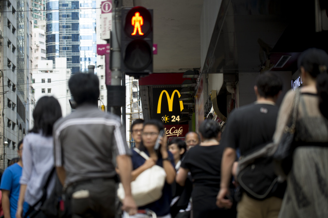 Pedestrians walk past a McDonald’s in Hong Kong.   Bloomberg