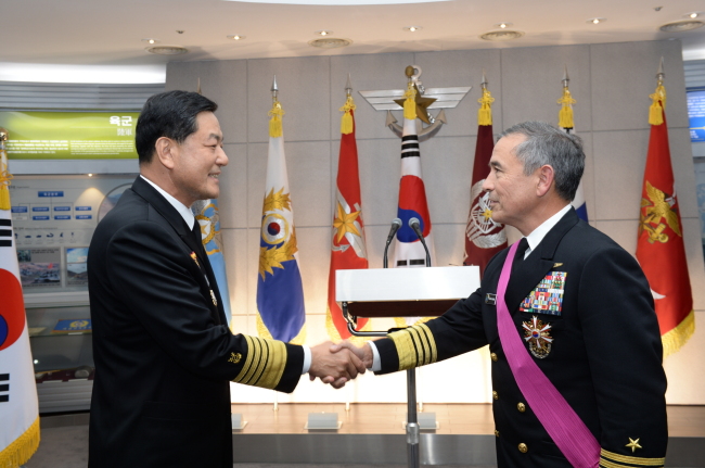 U.S. Pacific Fleet Commander Adm. Harry B. Harris (right) shakes hands with South Korea’s Chief of Naval Operations Adm. Hwang Ki-chul, after receiving Seoul’s national security medal at the Ministry of National Defense in Seoul on Monday.   Navy