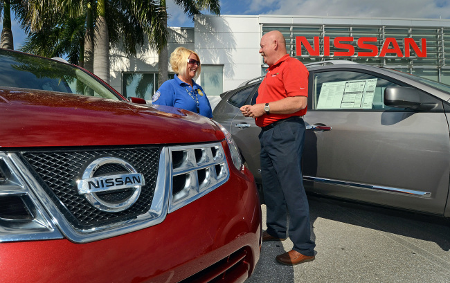 A sales associate helps customer shop for a Nissan Motor vehicle at the Royal Palm Nissan car dealership in Royal Palm Beach, Florida.   Blooomberg