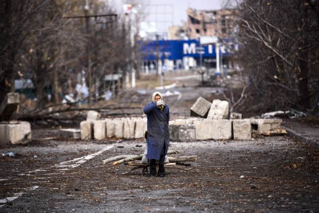 An elderly woman pulls a cart with firewood near the Donetsk airport in eastern Ukraine on Monday.   AFP-Yonhap