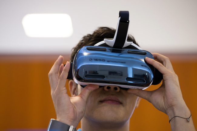 A visitor tries out the Gear VR headset, jointly developed by Samsung Electronics and Oculus VR Inc., at Samsung’s flagship store in Seoul.Bloomberg
