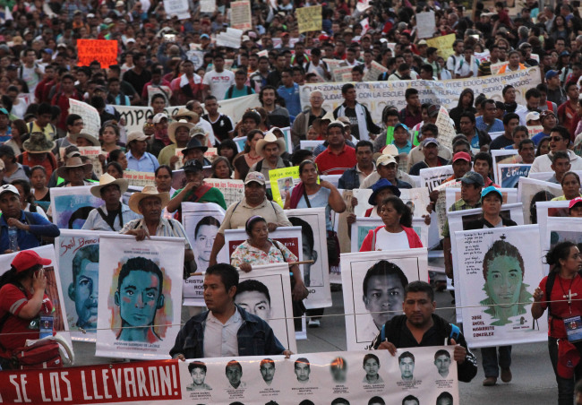 Demonstrators carrying posters of the missing students march in protest against the disappearance of 43 students in the state of Guerrero, in Mexico City, Wednesday. Federal police detained Iguala Mayor Jose Luis Abarca and his wife, Maria de los Angeles Pineda, who are accused of ordering the Sept. 26 attacks on teachers and college students that left six dead and 43 still missing.   AP-Yonhap