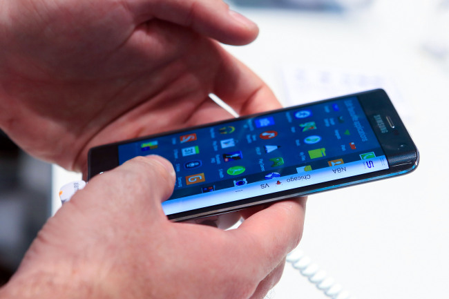 A visitor at the IFA electronics trade show held in Berlin in September tries out the Galaxy Note Edge, which features a curved display on the right side of the device.    Bloomberg