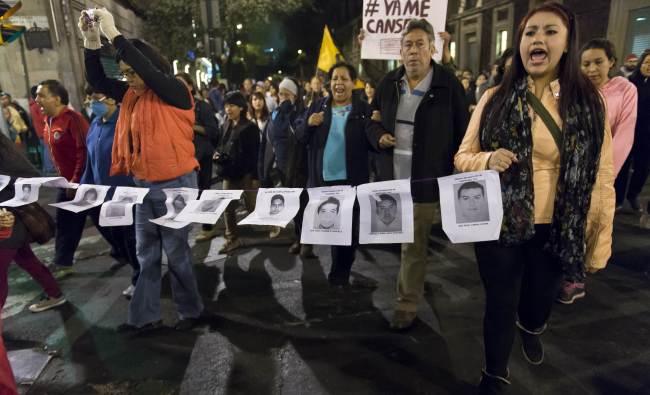 Demostrators march along the streets of Mexico City with the pictures of 43 missing students during a demostration on Saturday, demanding justice from the Mexican goverment for the massacre of the students.   AFP-Yonhap