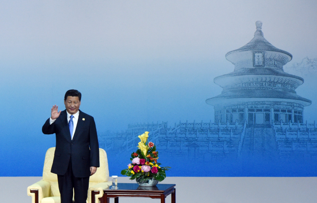 <YONHAP PHOTO-0959> China's President Xi Jinping waves as he stands up to give a speech to open the APEC CEO Summit as part of the Asia-Pacific Economic Cooperation (APEC) Summit at the China National Convention Center in Beijing, Sunday, Nov. 9, 2014. (AP Photo/Wang Zhao, Pool)/2014-11-09 12:37:27/ <저작권자 ⓒ 1980-2014 ㈜연합뉴스. 무단 전재 재배포 금지.>
China’s President Xi Jinping waves at the Asia-Pacific Economic Cooperation Summit at the China National Convention Center in Beijing on Sunday.   AP-Yonhap