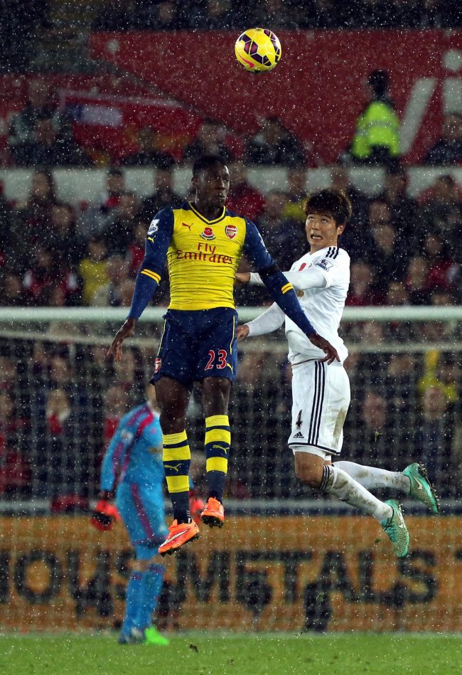 Swansea’s Ki Sung-yueng (right) and Arsenal’s Danny Welbeck vie for the ball on Sunday.   EPA-Yonhap