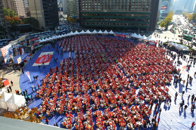Participants make kimchi at the huge kimchi-making event held during last year’s kimchi festival at Seoul Plaza.    Korea Tourism Organization