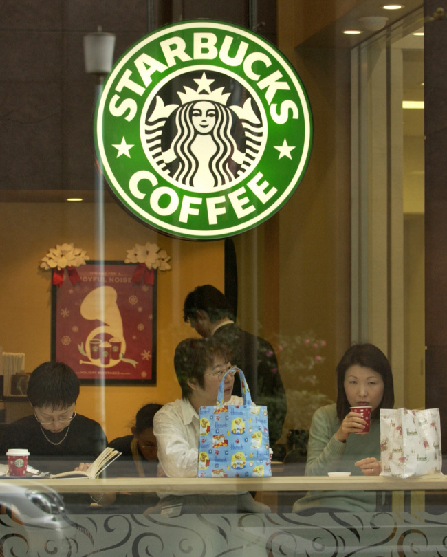 3 women drink coffee in a Starbucks coffee shop in Tokyo. (Bloomberg)
