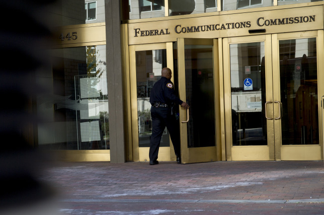 A security officer walks into the Federal Communications Commission (FCC) headquarters in Washington, D.C., U.S., on Monday, Nov. 10, 2014. President Barack Obama called for the "strongest possible rules" to protect the open Internet, advocating stricter controls than a regulator he appointed and causing shares of Comcast Corp. and other broadband providers to drop. Obama's comments tilt the White House against positions advocated by broadband providers and FCC Chairman Tom Wheeler. Photographer: Andrew Harrer/Bloomberg
A security officer walks into the Federal Communications Commission headquarters in Washington, D.C., Monday.    Bloomberg
