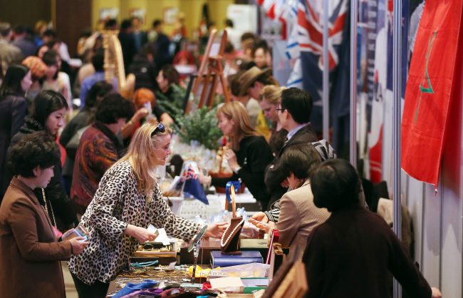 Visitors shop around at the SIWA and Diplomatic Community Bazaar in the 63 Building in Seoul on Monday.   Yonhap