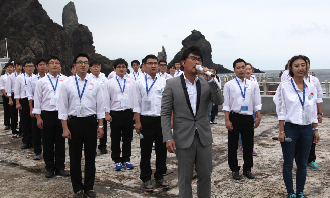 Singer Lee Seung-chul (center, front row) sings “That Day” with a choir of North Korean defectors, a song which expresses the desire for Korean reunification, on Aug. 14 on the easternmost islets of Dokdo.   Yonhap