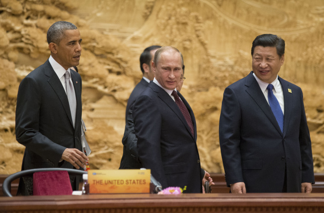 U.S. President Barack Obama (left), Chinese President Xi Jinping (right), and Russian President Vladimir Putin arrive at the APEC Summit plenary session at the International Convention Center, in Beijing on Tuesday.  (AP-Yonhap)