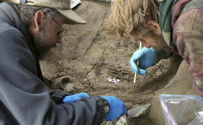 Professors Ben Potter (left) and Josh Reuther excavate a burial pit at the Upward Sun River site in central Alaska.   AP