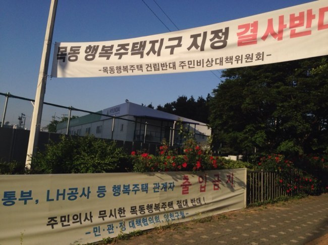 이달 13일 열릴 예정이었던 목동 행복주택 지구지정 취소 선고공판이 27일로 연기됐다. 사진은 목동 유수지 입구에 주민들이 걸어놓은 지구지정 반대 현수막.