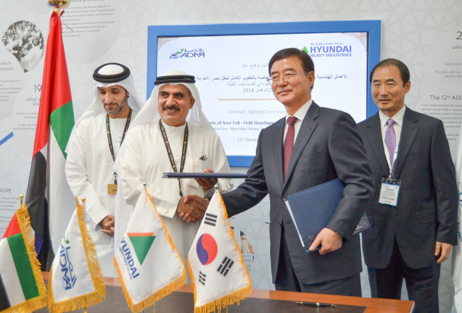 Hyundai Heavy Industries vice president Kim Jong-do (second from right) shakes hands with Ali R. Al-Jarwan (second from left), CEO of ADMA-OPCO, an Abu Dhabi-based marine operating company, after signing a 2.1 trillion won offshore construction project deal in Abu Dhabi, UAE, Tuesday.   Hyundai Heavy