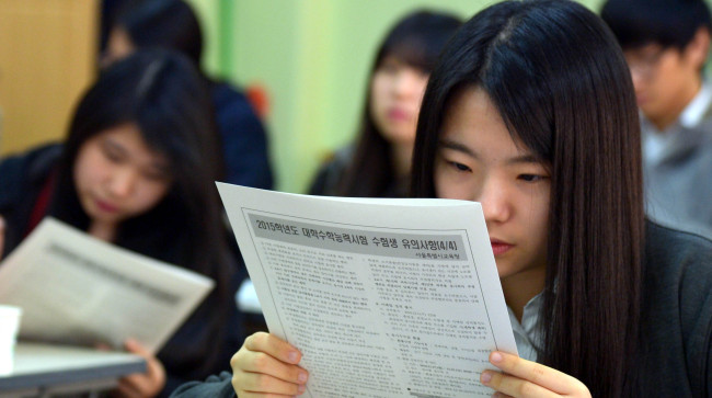 A student looks over the guidelines for the college entrance exam at Seocho High School in Seoul on Wednesday. About 640,000 Korean students compete for freshman seats in some 400 universities nationwide at the crucial exam slated for Thursday.   Kim Myung-sub/The Korea Herald