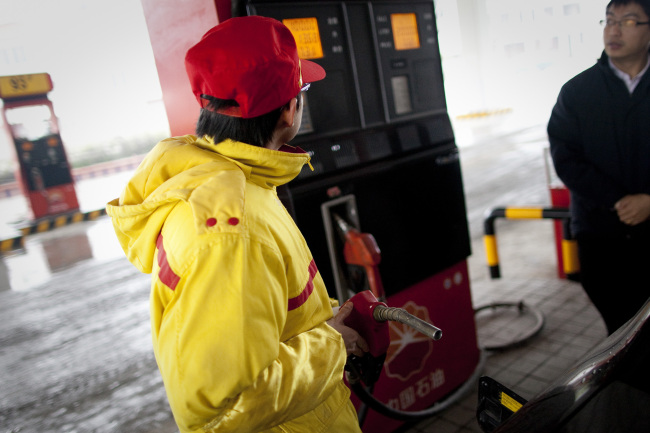 A customer buys fuel at a gas station in Wujiang, Guizhou province, China. (Bloomberg)