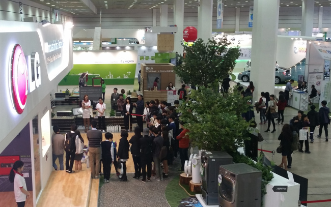 Spectators gather at a booth where green tech-integrated products are showcased during the Eco-Expo Korea 2014 at Coex in Samseong-dong, Seoul, in late October.   KEITI