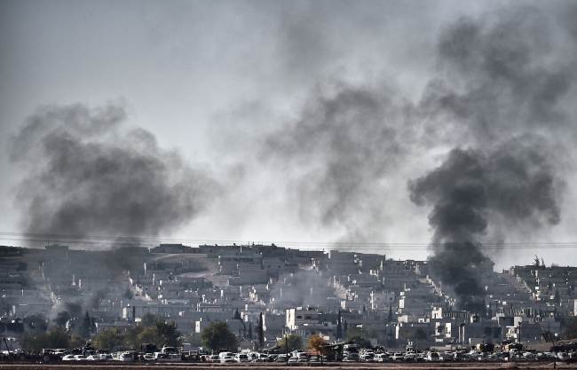 Smoke rises after the shelling of the city of Kobane, Syria, as seen from the village of Mursitpinar, Sanliurfa province, Turkey, Wednesday.   AFP-Yonhap