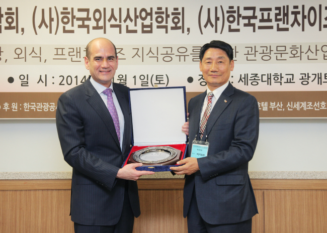 Eric Swanson (left), general manager of Millennium Seoul Hilton, receives the top tourism prize awarded by the Academy of Korea Hospitality and Tourism in Seoul on Nov. 1.   Millennium Seoul Hilton