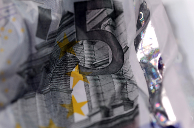 A crumpled five euro note sits arranged for a photograph in London.   Bloomberg