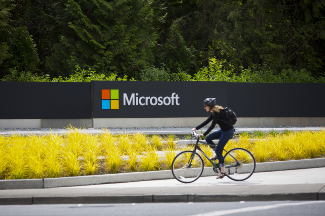 A woman rides a bicycle past a Microsoft sign on the company’s main campus in Redmond, Washington, D.C.   Bloomberg