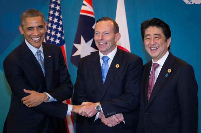U.S. President Barack Obama (left), Australian Prime Minister Tony Abbott (center) and Japanese Prime Minister Shinzo Abe, shake hands at the start of their meeting at the G20 Summit in Brisbane, Australia, Sunday.   AP-Yonhap