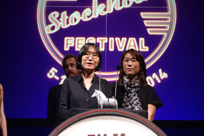 Korean filmmaker July Jung (left) gives an acceptance speech after receiving the Best First Film award at the Stockholm International Film Festival in Stockholm, Sweden, Friday.  Yonhap