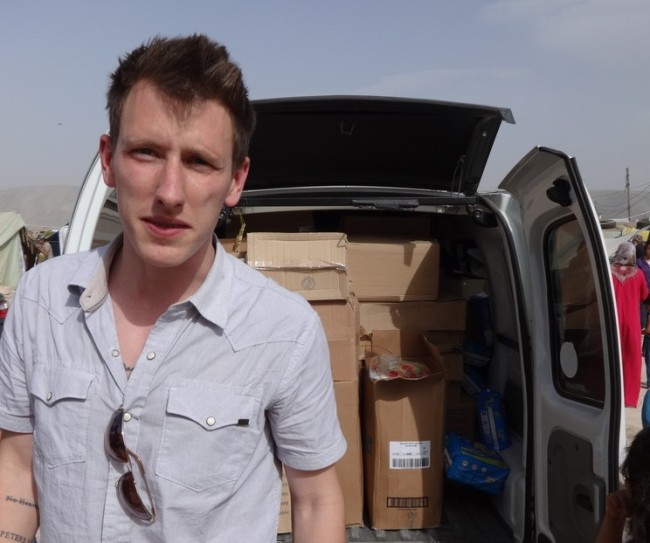 This undated file photo provided by the Kassig family shows Peter Kassig standing in front of a truck filled with supplies for Syrian refugees.   AP-Yonhap