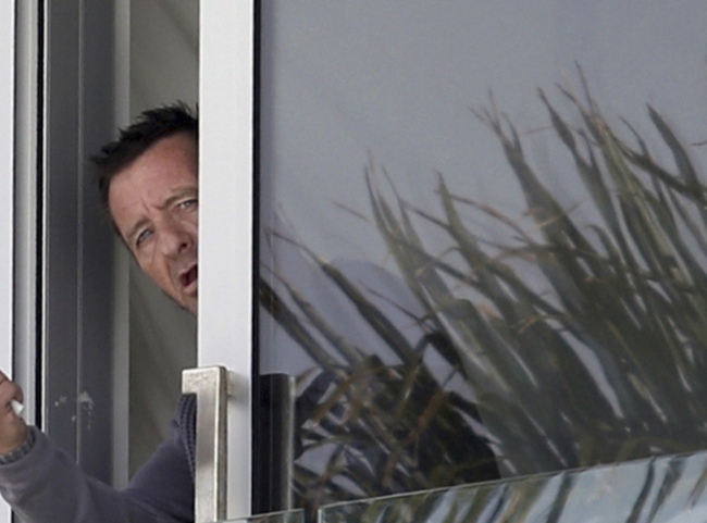 Phil Rudd, drummer for the rock band AC/DC, looks out from a window at his house in Tauranga, New Zealand, on Nov. 6.   AP-Yonhap