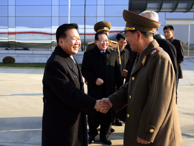 North Korean leader Kim Jong-un’s special envoy Choe Ryong-hae (left), a senior member of the Presidium of the Political Bureau and secretary of the Central Committee of the Workers’ Party, shakes hands with Hwang Pyong-so, director of the General Political Bureau of the Korean People’s Army, as he and his delegation members leave the Pyongyang Airport in Pyongyang for Russia, Monday.    AP-Yonhap