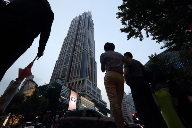 Pedestrians walk past the K11 Art Mall in Shanghai operated by New World Development, an affiliate of Chow Tai Fook owned by Cheng Yu-tung.    (Bloomberg)