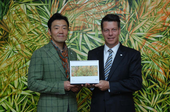 Michael Grund (right), managing director of Merck Korea, poses with Korean painter Kim Geon-il at an event to unveil the company’s 2015 calendar featuring the artist’s paintings in Seoul on Tuesday.   Merck Korea